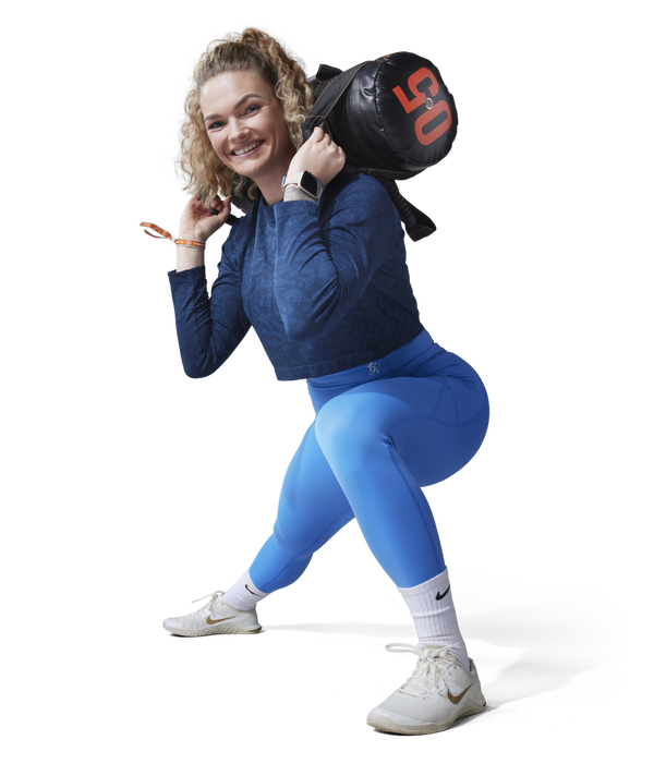 Lady doing leg exercise with one stretched leg and a weight bag on her shoulders