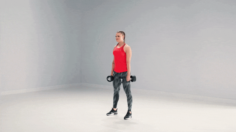 Frau macht Kniebeugen mit Kurzhanteln in einem Studio-Workout